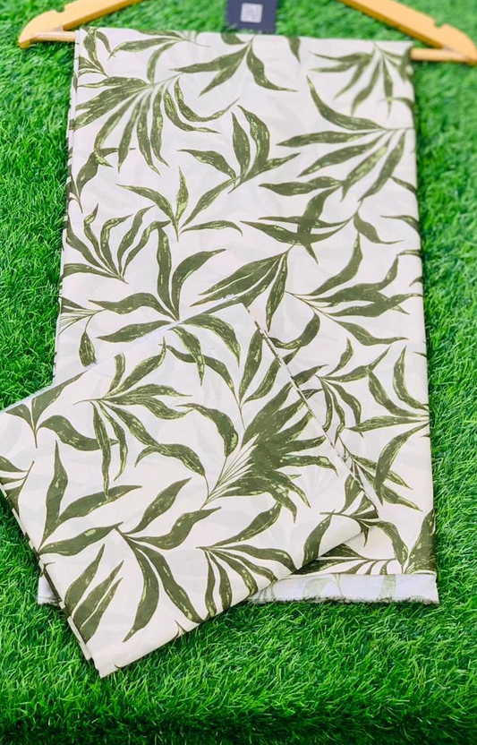 Folded fabric with leaf pattern on a hanger against a green grass background